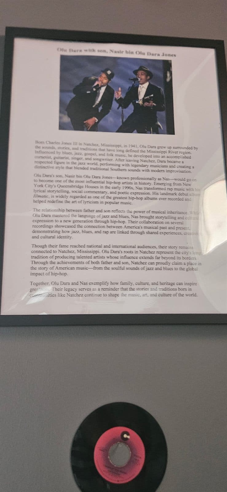 A framed feature with a photograph and accompanying record on the exhibit wall.
