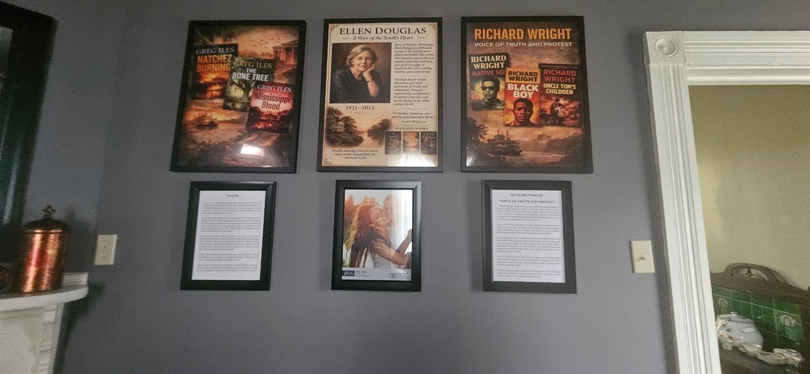 A wall of framed exhibits interpreting Natchez literary and cultural heritage.