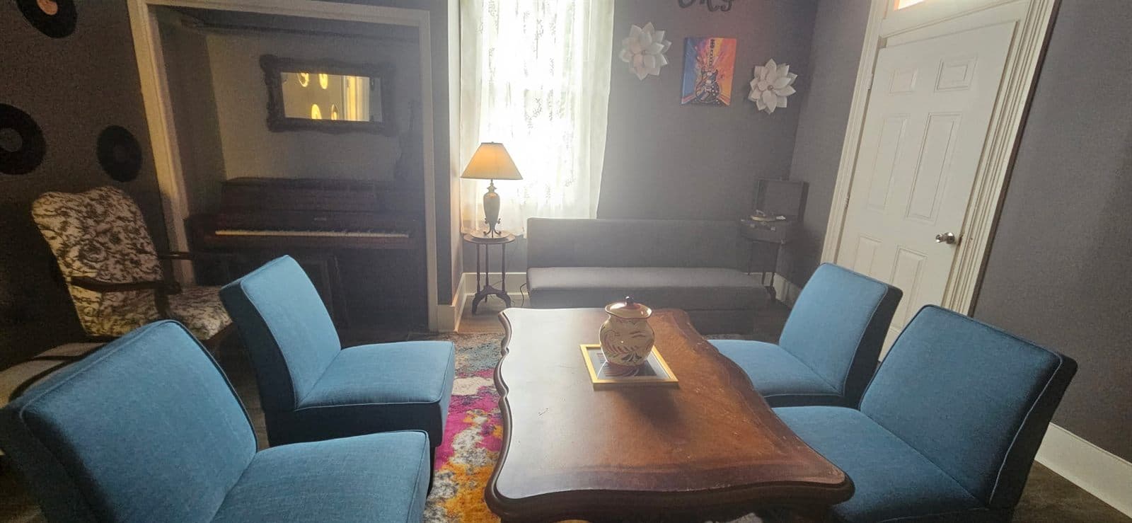 The music room at The Legacy at Madison, with blue velvet chairs around a wooden table.