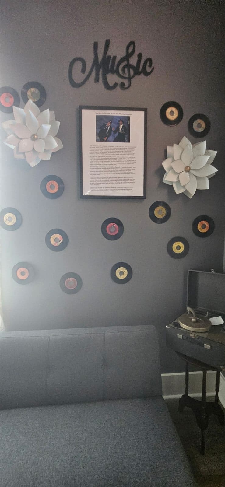A corner of the music room with a cursive ‘Music’ sign, framed feature, and seating.