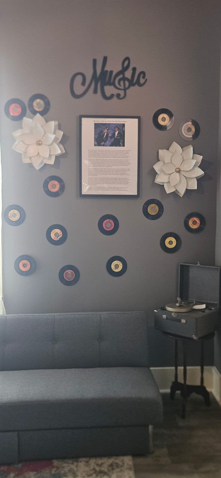 A decorative ‘Music’ sign with records and a framed exhibit in the storytelling room.