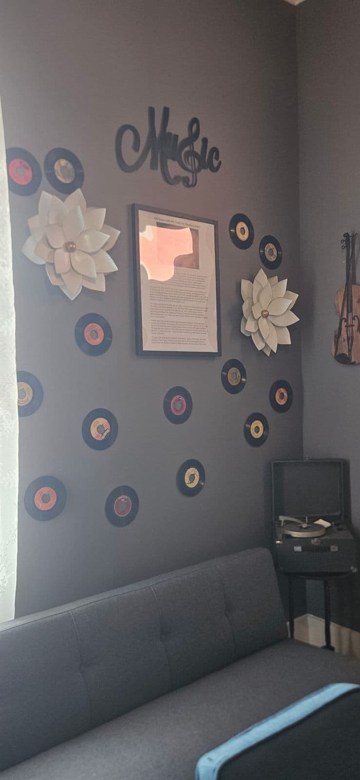 Records and framed features above a daybed in the music room.