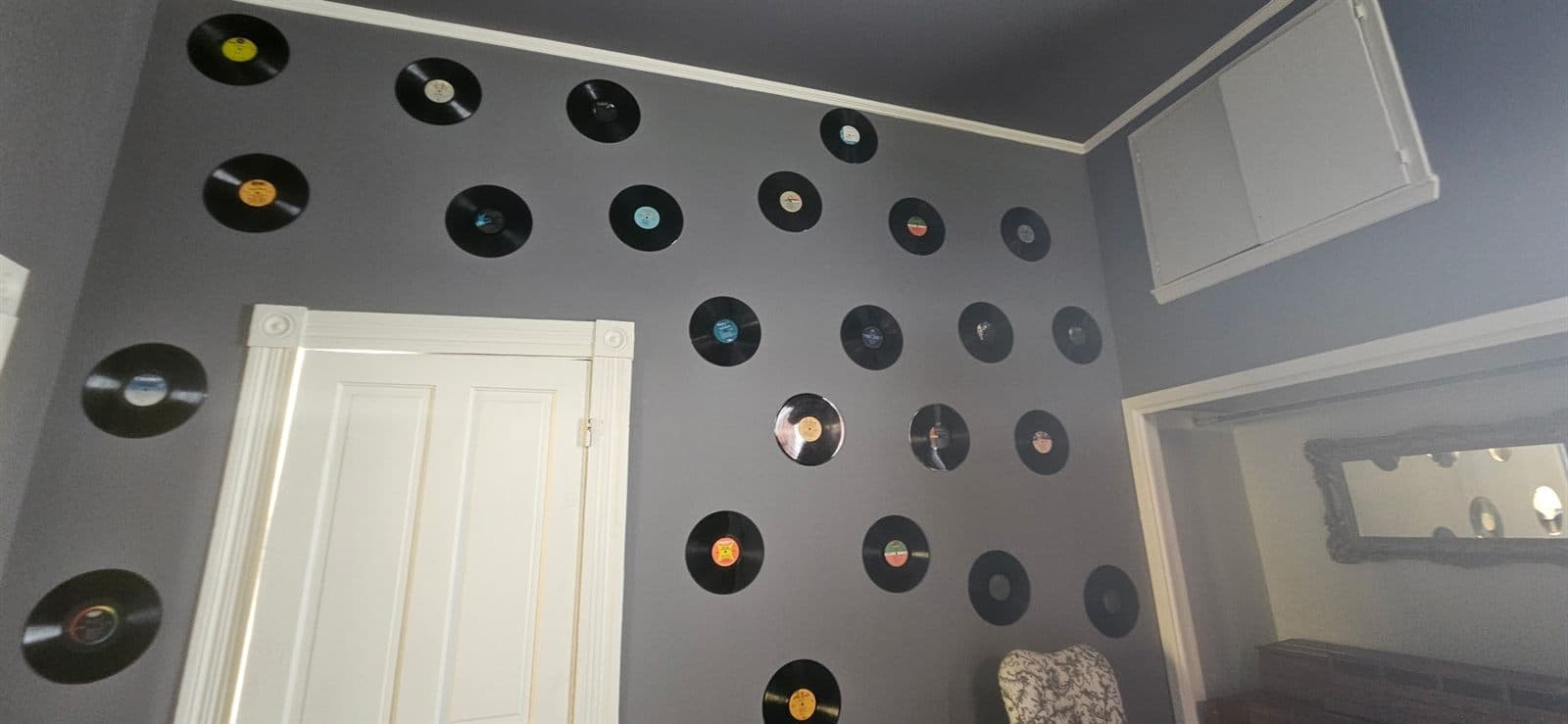 A wall arranged with vinyl records in the music and storytelling room.
